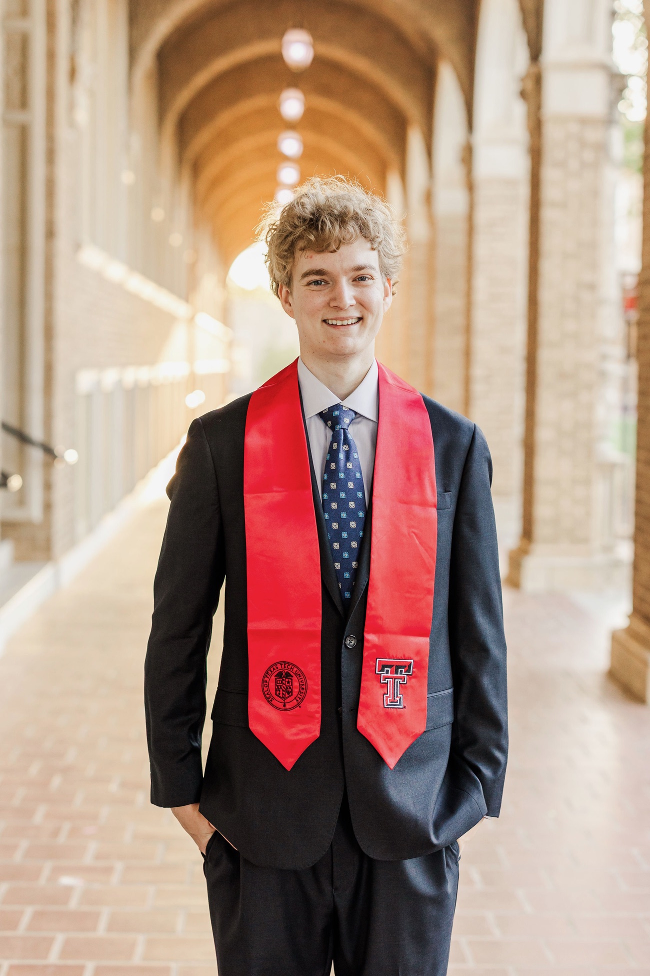 Ethan Hennenhoefer standing in a sunlit brick archway